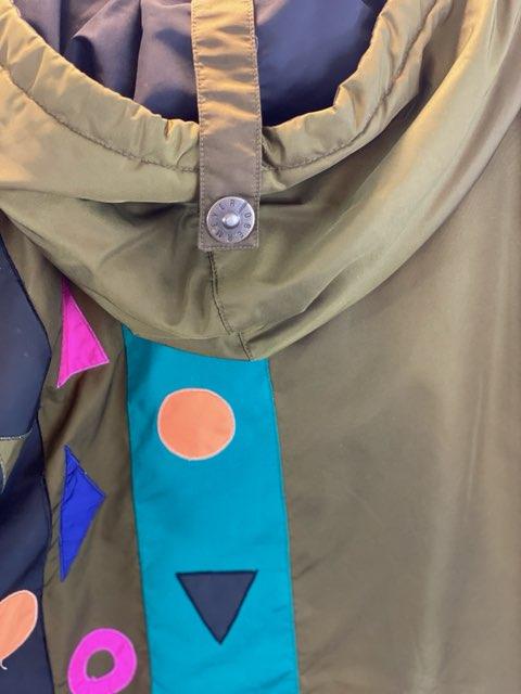 Pea Green - Geometric Pattern/Design on Coat Medium Size Polyester Lining Zipper and Snap Front Closure Two (2) Zipper Front Pockets Two (2) Inside Pockets Attached Hood 27” Length 23” Sleeve 23” Chest