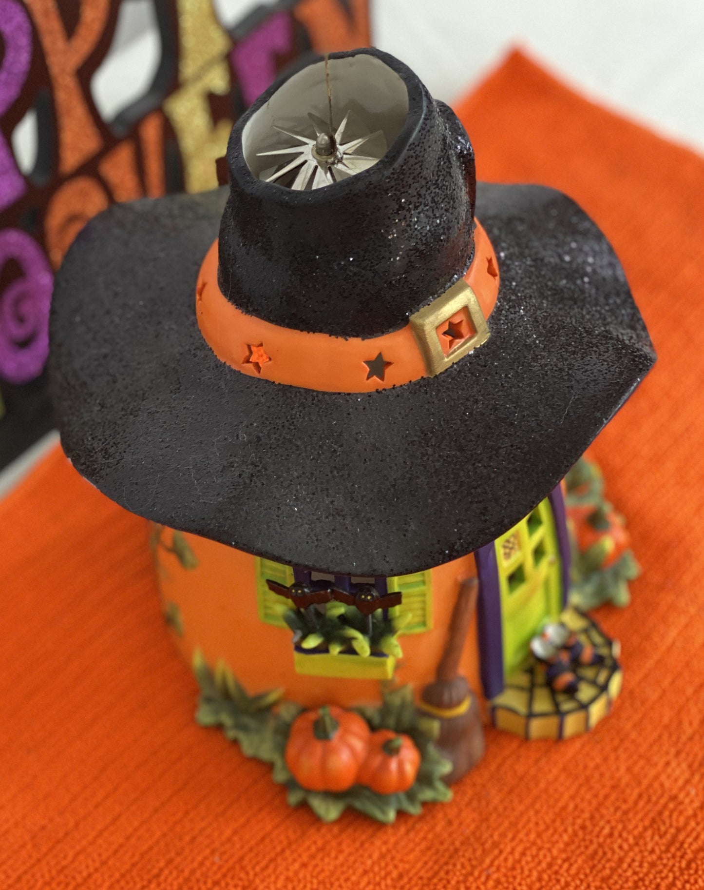 Ceramic Witch’s Home Decorated with: Witch Hat Roof Witch’s Shoes at Doorstep Witch’s Broom Spider Web Pumpkins Opening for candle for Lighting