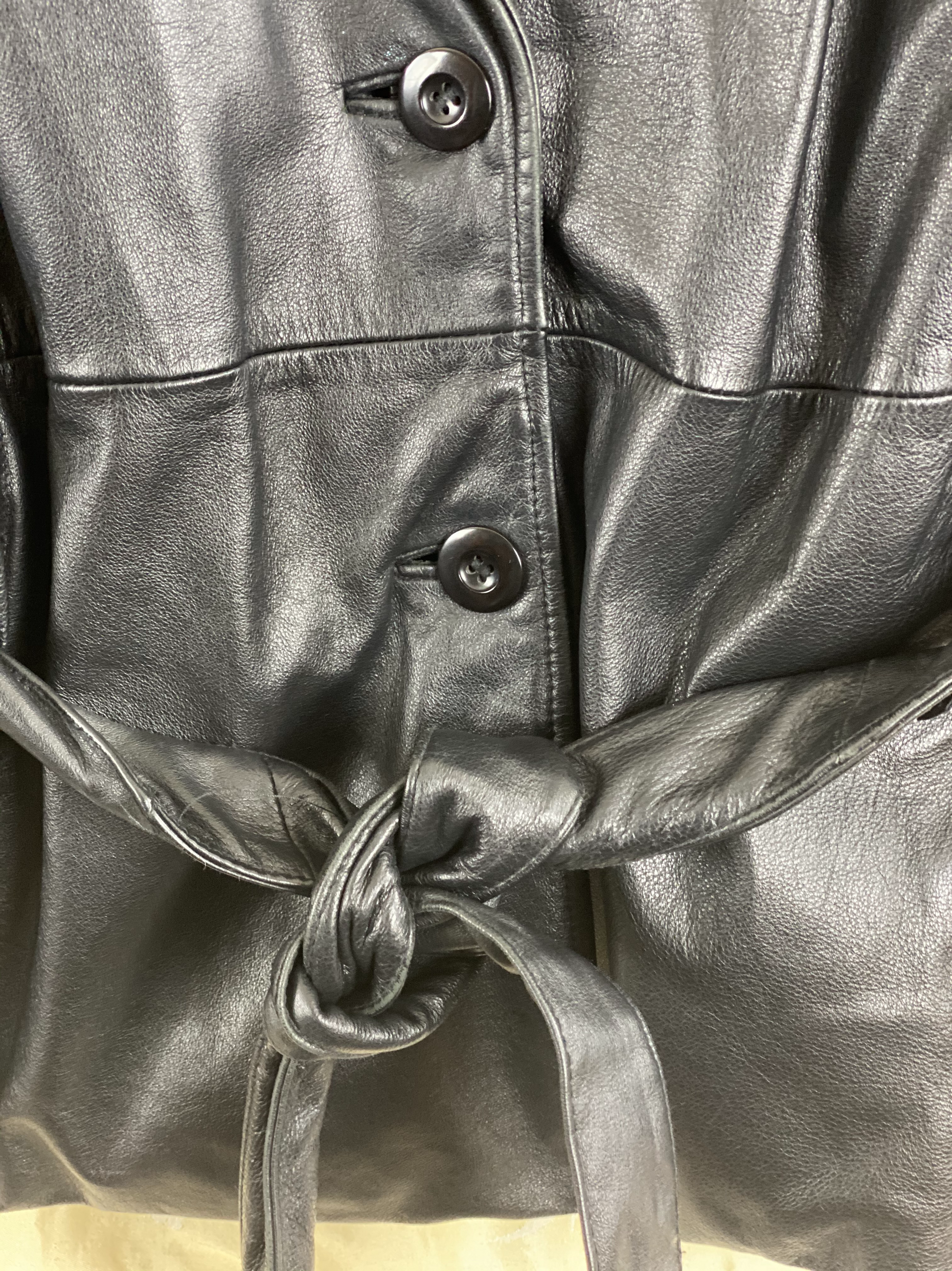 Pre-Owned - Excellent Condition   Soft-Leather Coat  Size Large  Two (2) Button & Belt Front Closure  Removable Lining  Two (2) Front/Side Pockets  25” Shoulder to Bottom; 23” Sleeve; 22” Across Chest