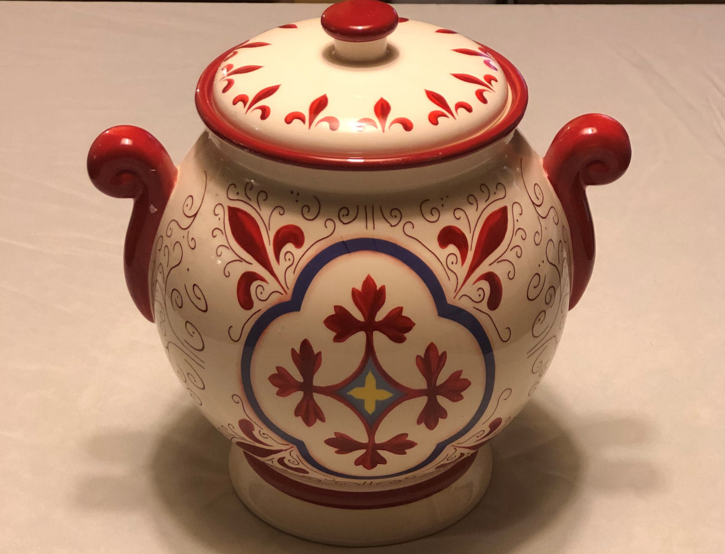 Decorative Red and White Colors  Approximately 9” High  Fleur de Lis Design  Two (2) Side Handles  Round Shape with Lid