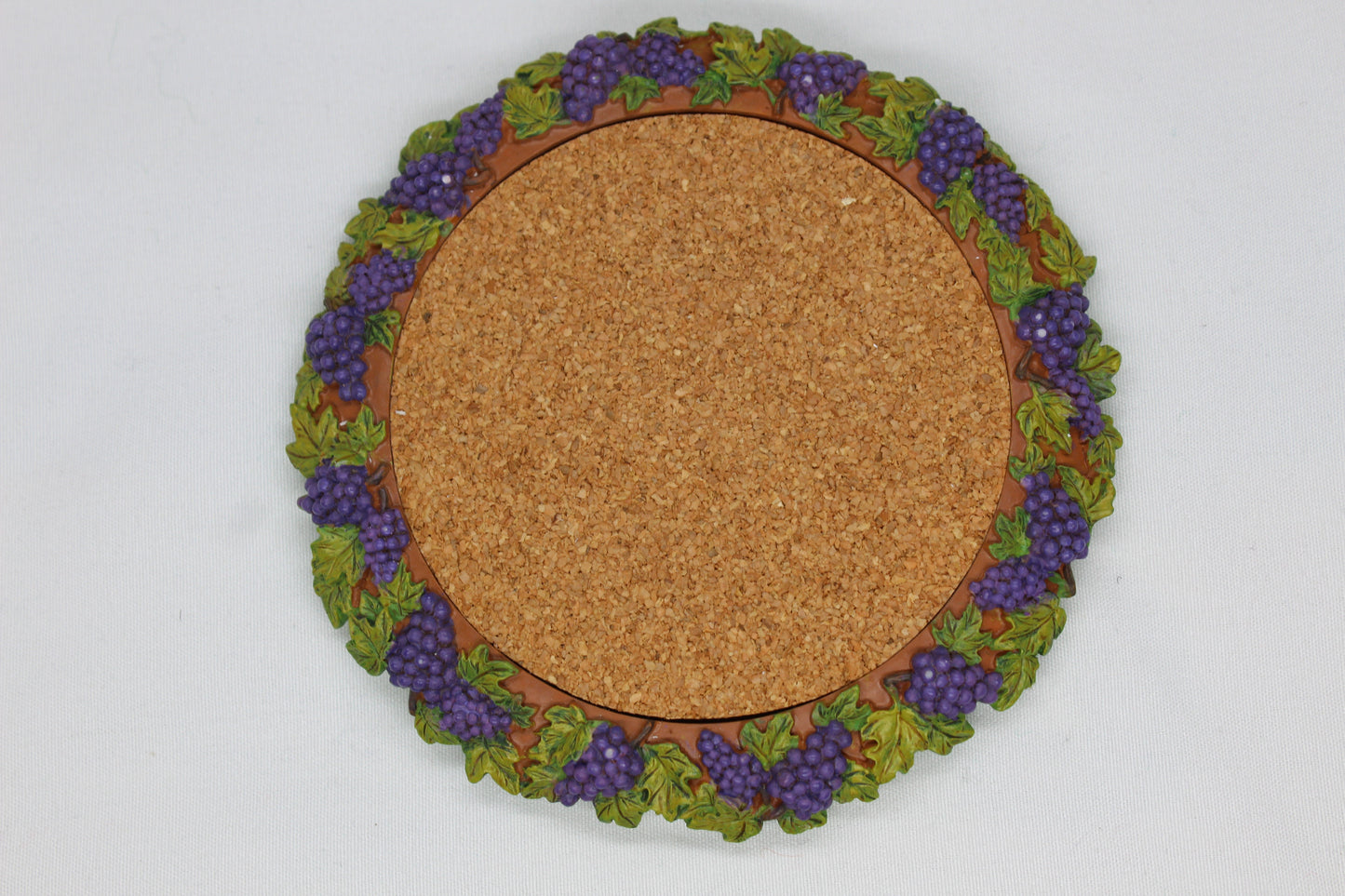 Set of 4 Coasters -  Apple Pattern (2), Grape   Pattern (1); Pear Pattern (1)  Russ Wine Cellar - Berrie and Company  Approx:  3.75” Round  Ceramic With Cork Inlay