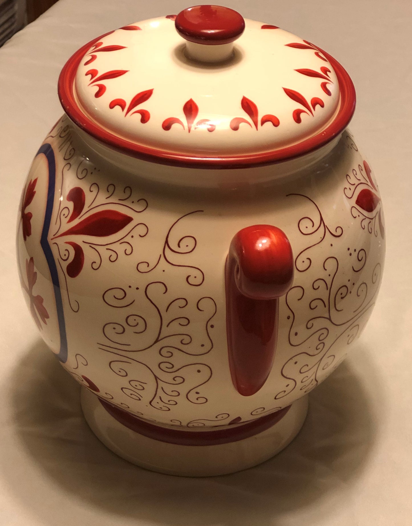 Decorative Red and White Colors  Approximately 9” High  Fleur de Lis Design  Two (2) Side Handles  Round Shape with Lid