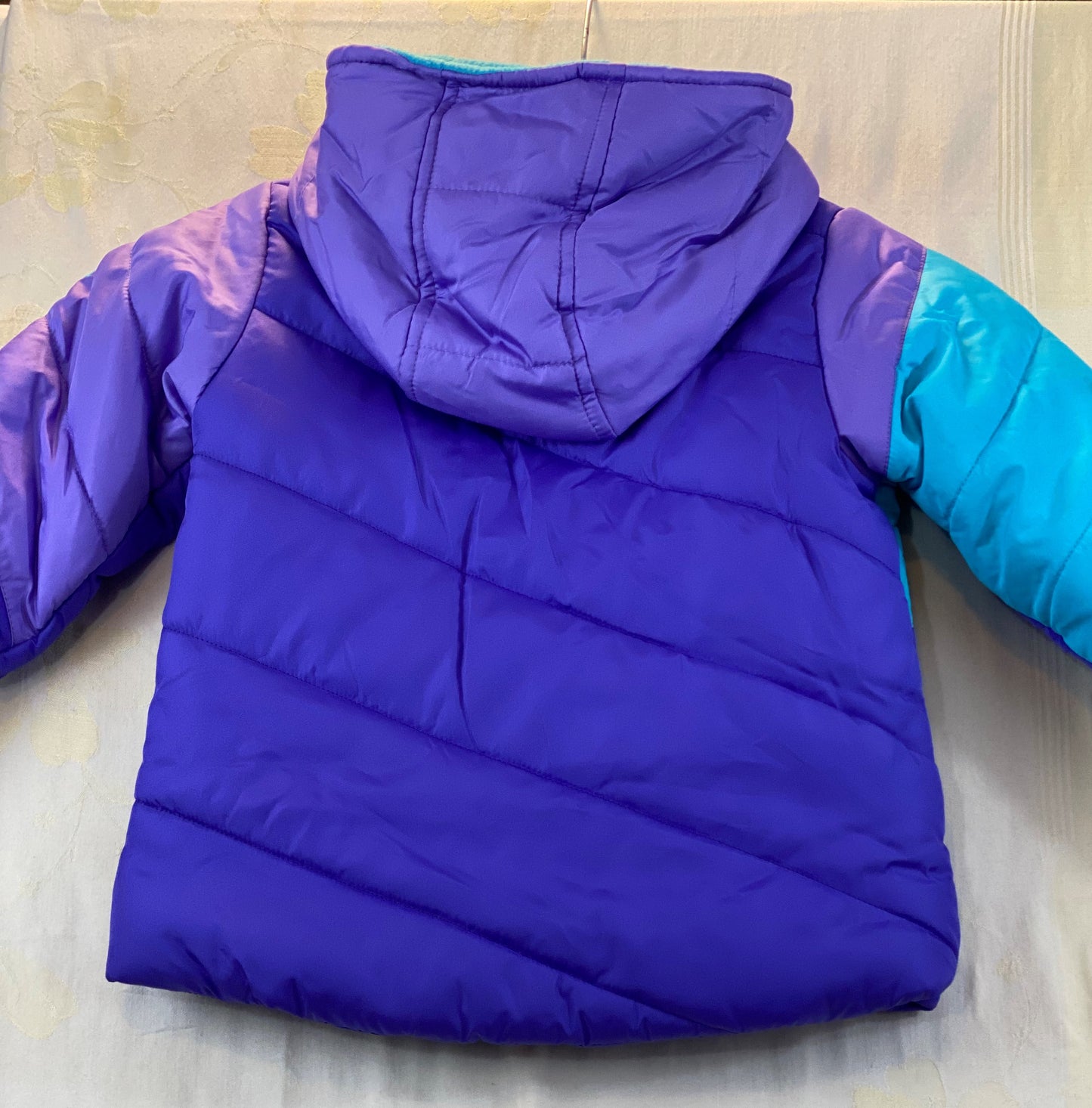 Pre-Owned - Excellent Condition   Girl’s Coat - Size 4-T  Purple & Aqua Color  Attached Hood  Two (2) Front Pockets  16” Shoulder to Bottom;  14” Sleeve;  13’ Across Chest  100% Polyester