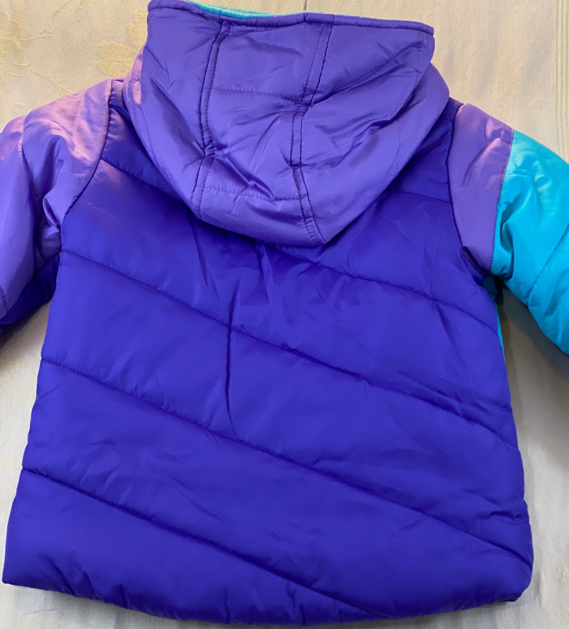 Pre-Owned - Excellent Condition   Girl’s Coat - Size 4-T  Purple & Aqua Color  Attached Hood  Two (2) Front Pockets  16” Shoulder to Bottom;  14” Sleeve;  13’ Across Chest  100% Polyester