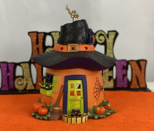 Ceramic Witch’s Home  Decorated with:   Witch Hat Roof  Witch’s Shoes at Doorstep  Witch’s Broom  Spider Web  Pumpkins    Opening for candle for Lighting