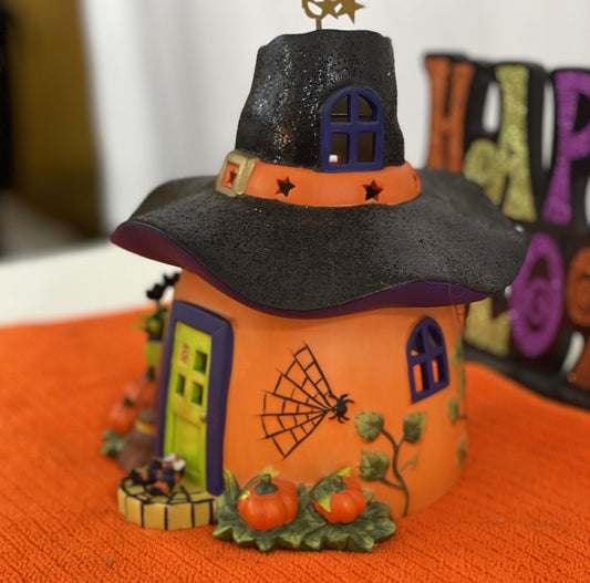 Ceramic Witch’s Home  Decorated with:   Witch Hat Roof  Witch’s Shoes at Doorstep  Witch’s Broom  Spider Web  Pumpkins    Opening for candle for Lighting