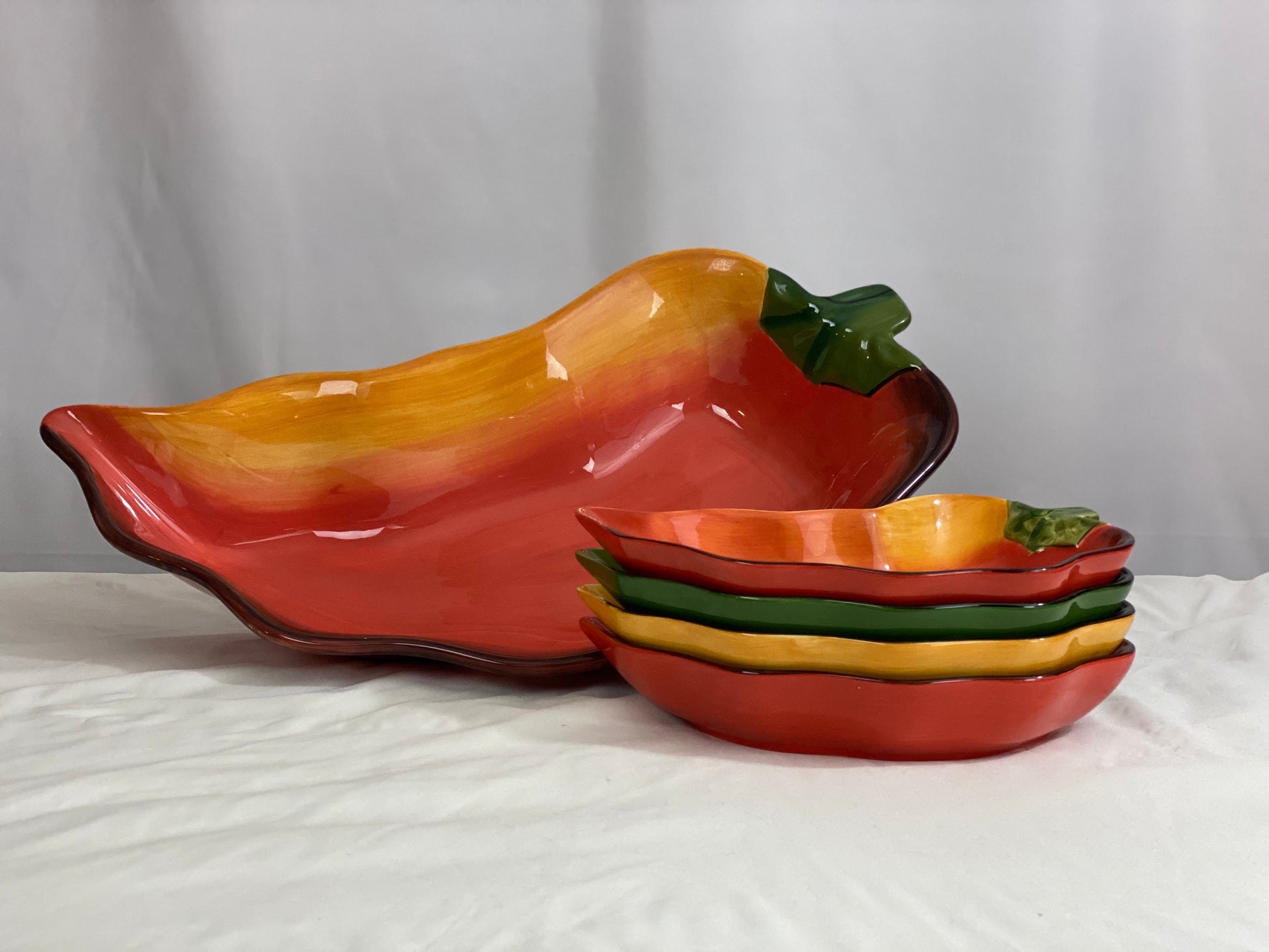 Chili Pepper Serving Set  Clay Art/Ceramic  One (1) Main Dish -- Red/Yellow  Approx 17” L x 8” W  Four Serving Dishes --  2 Red; 1 Yellow; 1 Green                                                                                                                                                                                                                                                                             Approx 9” L x 4 ½ ”W