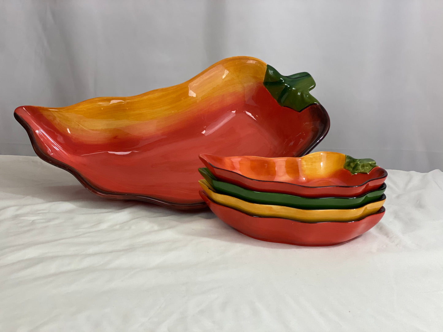 Chili Pepper Serving Set  Clay Art/Ceramic  One (1) Main Dish -- Red/Yellow  Approx 17” L x 8” W  Four Serving Dishes --  2 Red; 1 Yellow; 1 Green                                                                                                                                                                                                                                                                             Approx 9” L x 4 ½ ”W