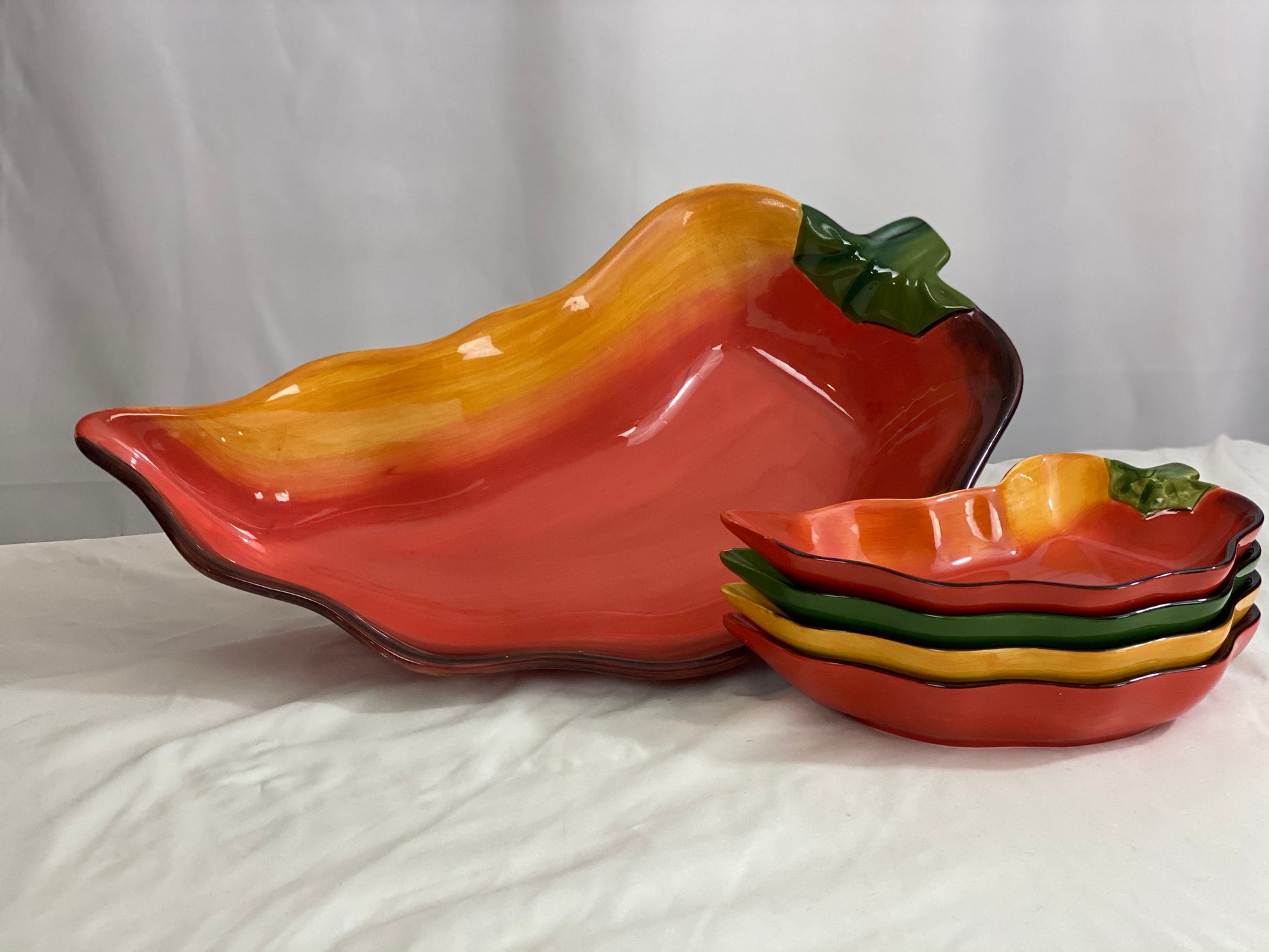 Chili Pepper Serving Set  Clay Art/Ceramic  One (1) Main Dish -- Red/Yellow  Approx 17” L x 8” W  Four Serving Dishes --  2 Red; 1 Yellow; 1 Green                                                                                                                                                                                                                                                                             Approx 9” L x 4 ½ ”W