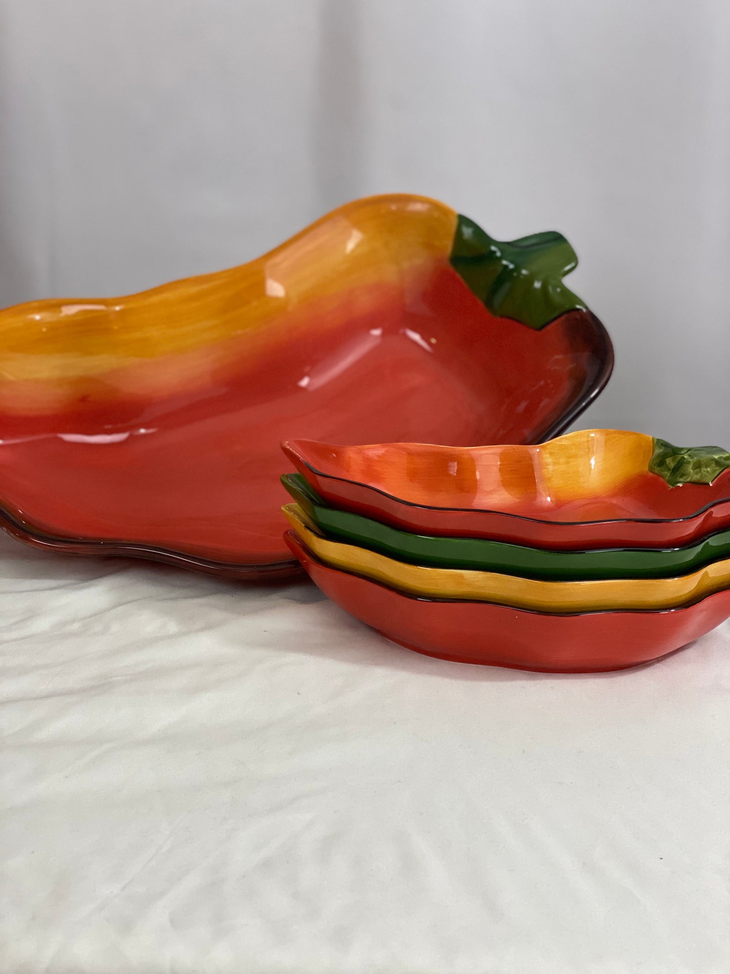 Chili Pepper Serving Set  Clay Art/Ceramic  One (1) Main Dish -- Red/Yellow  Approx 17” L x 8” W  Four Serving Dishes --  2 Red; 1 Yellow; 1 Green                                                                                                                                                                                                                                                                             Approx 9” L x 4 ½ ”W