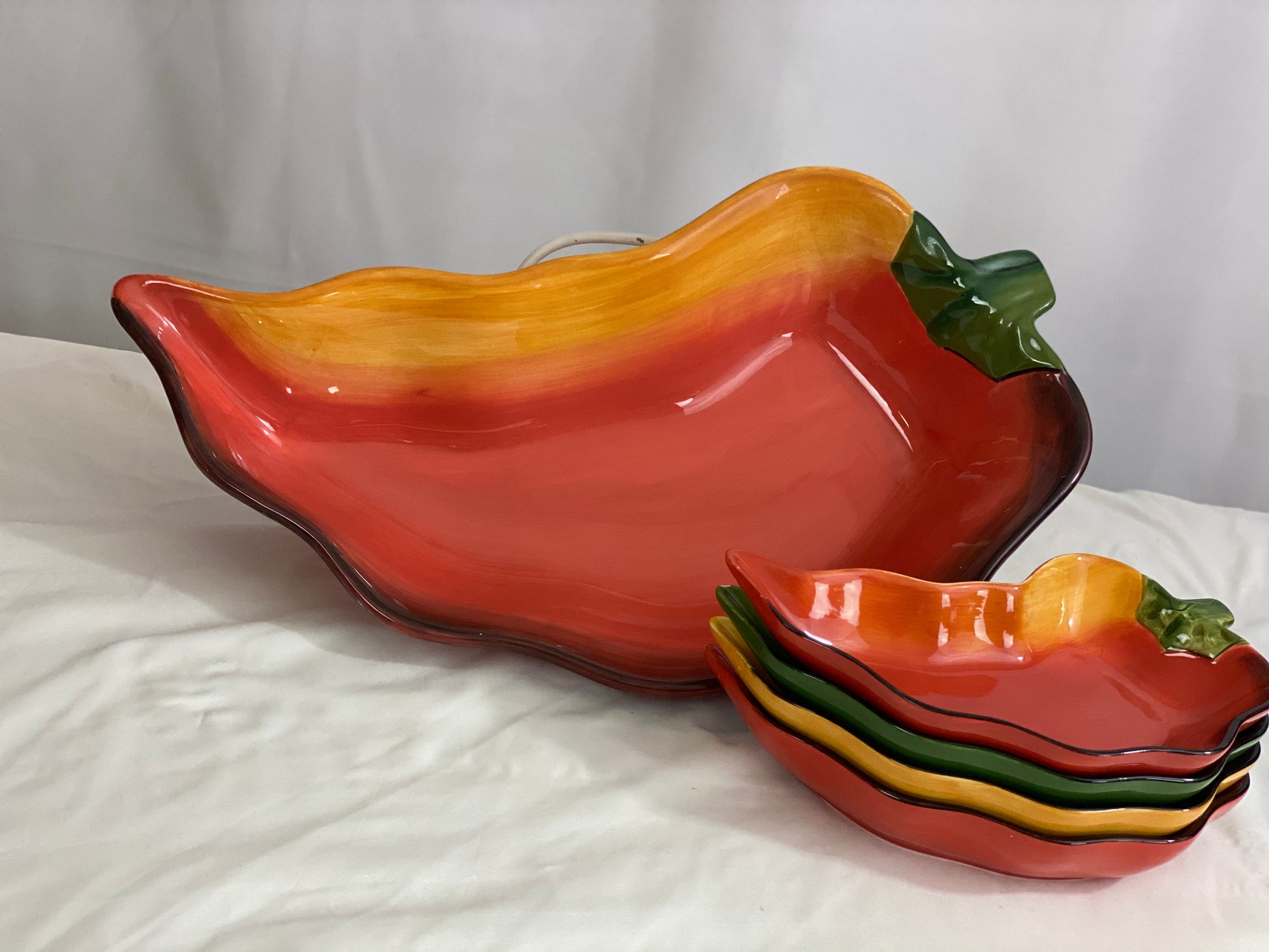 Chili Pepper Serving Set  Clay Art/Ceramic  One (1) Main Dish -- Red/Yellow  Approx 17” L x 8” W  Four Serving Dishes --  2 Red; 1 Yellow; 1 Green                                                                                                                                                                                                                                                                             Approx 9” L x 4 ½ ”W