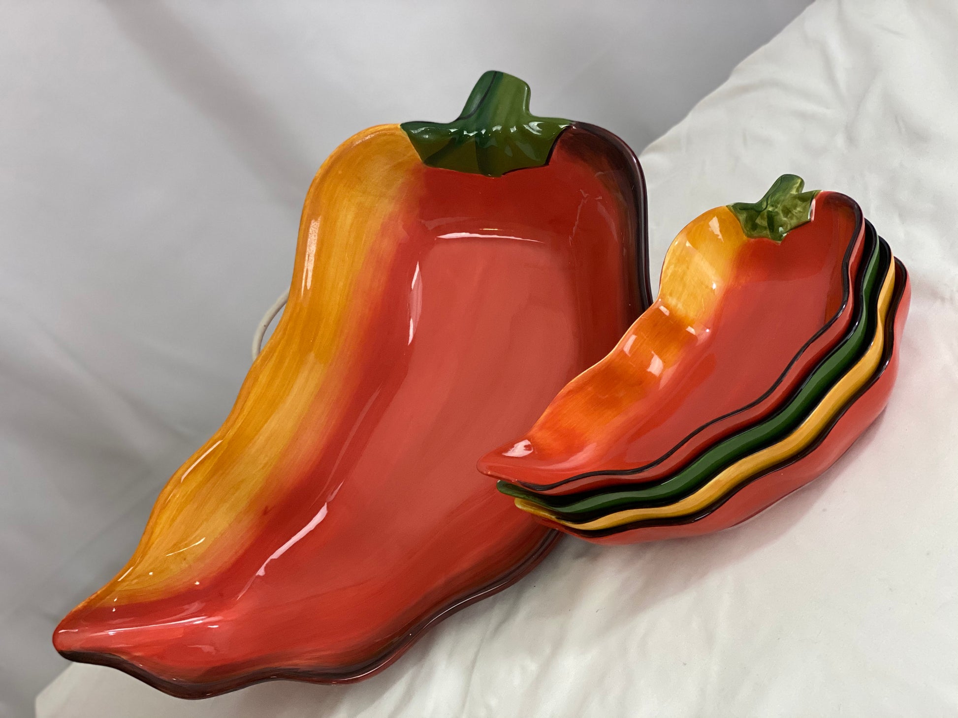 Chili Pepper Serving Set  Clay Art/Ceramic  One (1) Main Dish -- Red/Yellow  Approx 17” L x 8” W  Four Serving Dishes --  2 Red; 1 Yellow; 1 Green                                                                                                                                                                                                                                                                             Approx 9” L x 4 ½ ”W