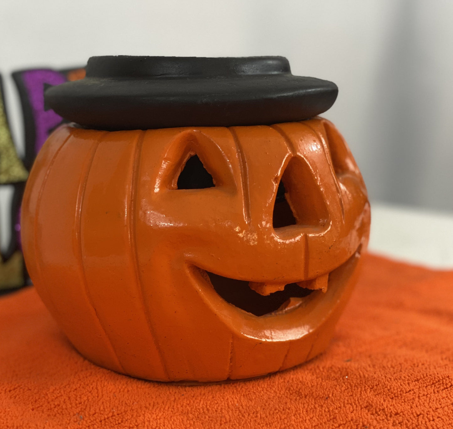 Orange Pumpkin with Black Hat  Made of Stone  Approx. 7.5” H x 6.5” W  Opening for Candle