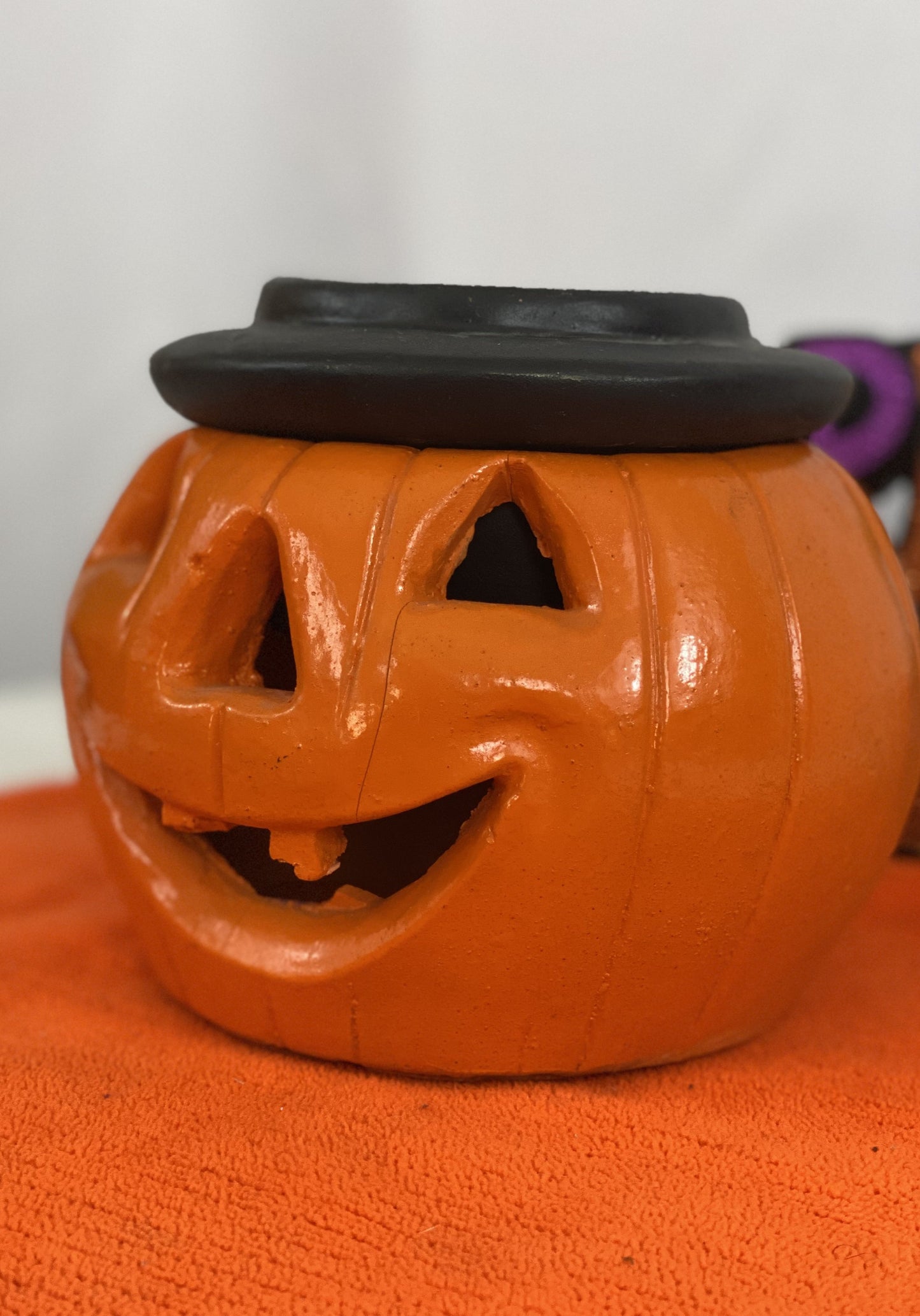 Orange Pumpkin with Black Hat  Made of Stone  Approx. 7.5” H x 6.5” W  Opening for Candle