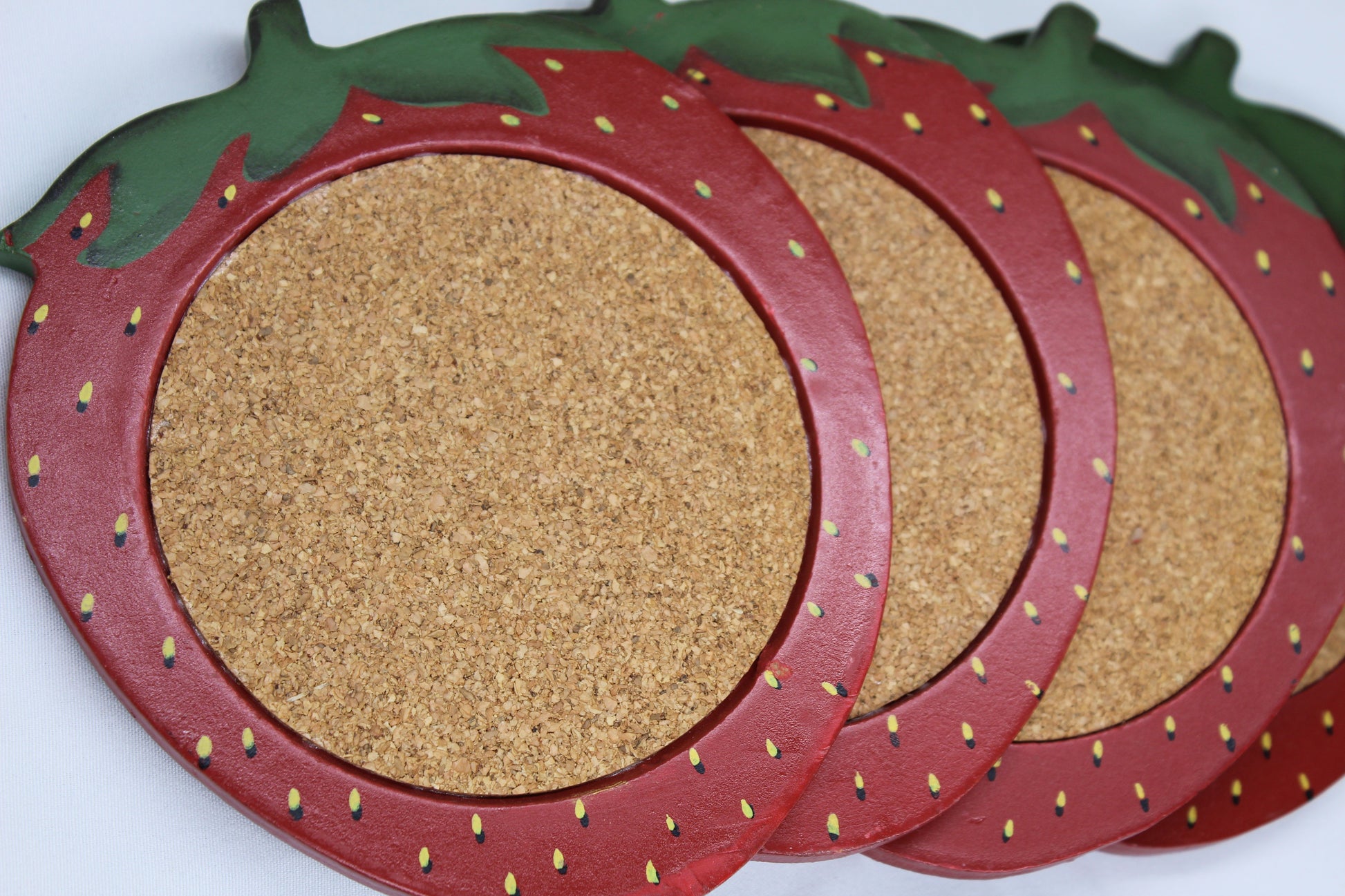 Set of four (4) Wooden Coasters 			Cork Inlay 			Strawberry Design 			Holder -  Wooden Shaped/Designed                Basket With Strawberries 	                                  Approx:    4.5”W x 5”H