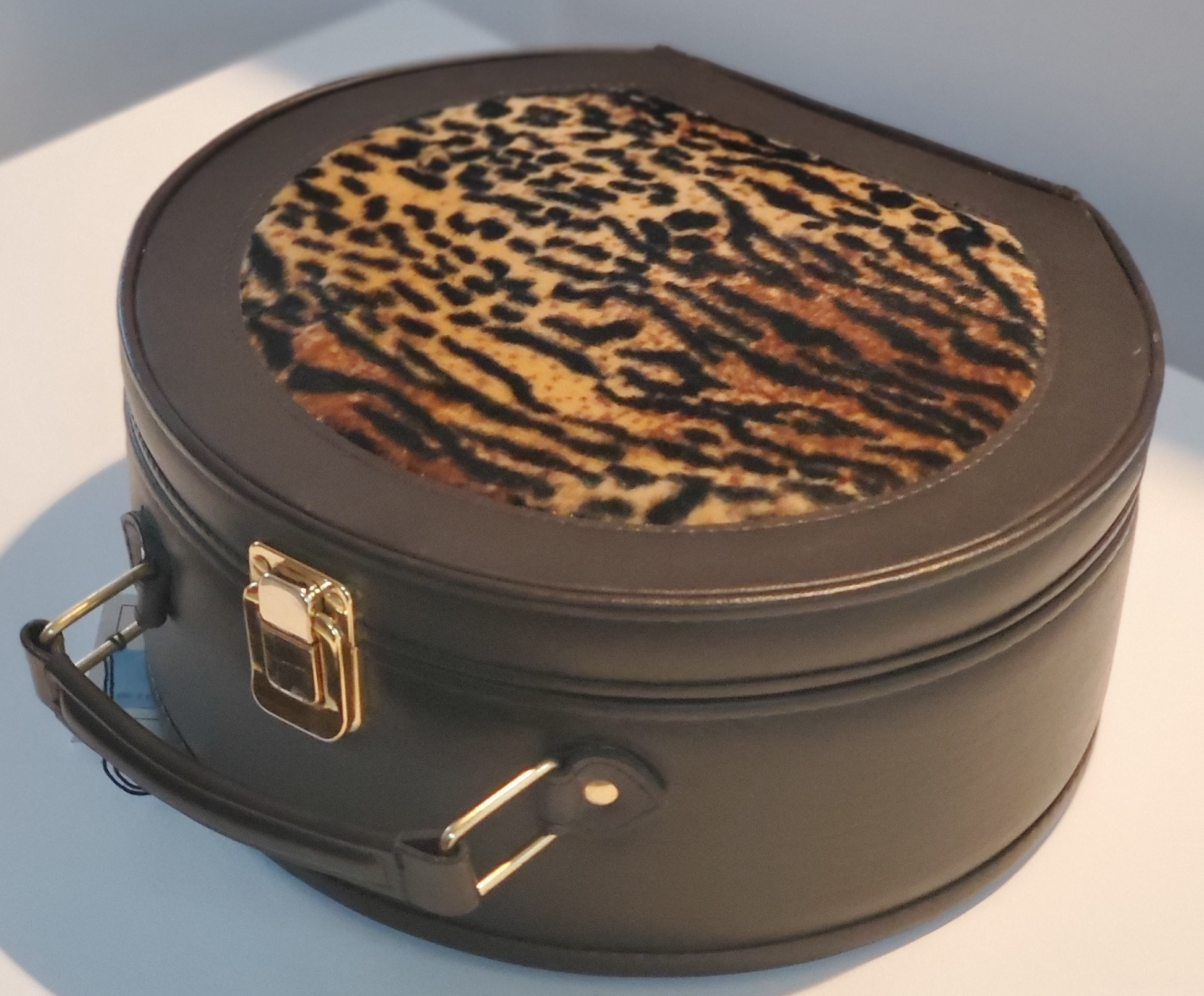 Leather Cosmetic Bag with Leopard Accent On Top and Bottom  Leather Handle for Carrying  Gold-Tone Clasp for Secure Closure  Approx Size:  11” W x 10” H x 5”  D  Round Shape