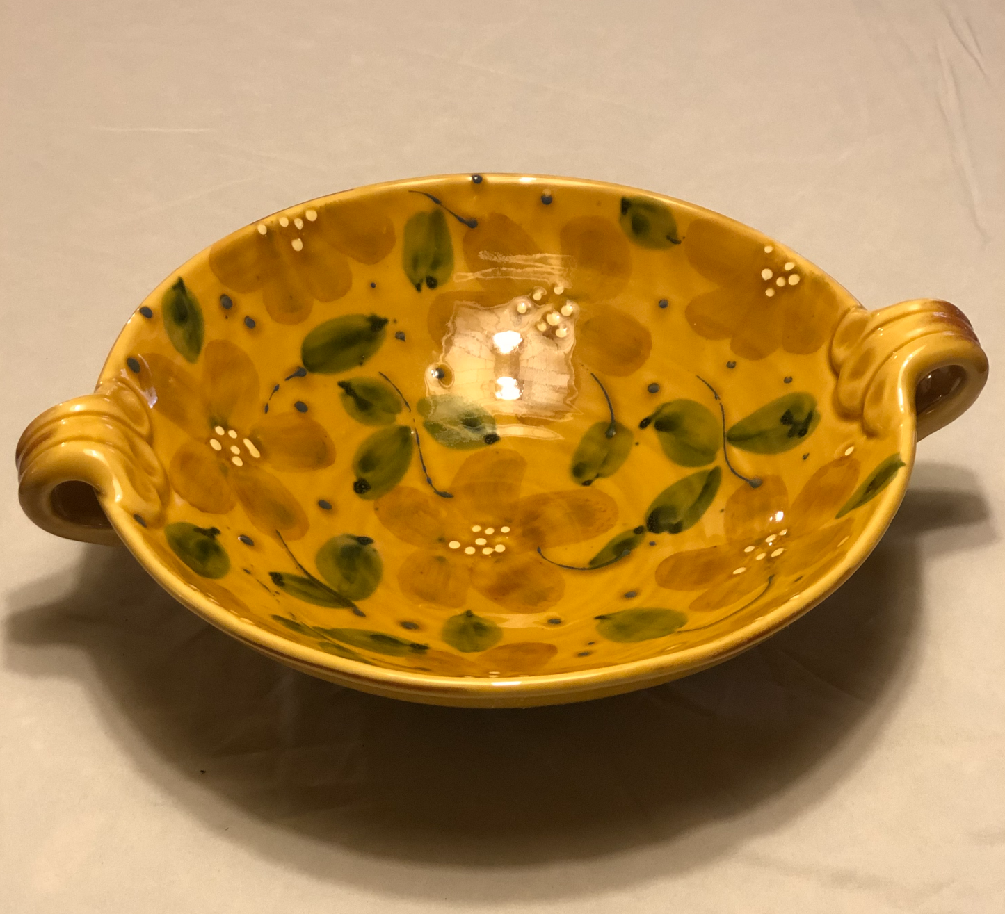 Ceramic Bowl - Approx: 12” Diameter  Two (2) handles for easy carrying  Handle-to-Handle - Approx: 15”  Gold Background with Green & Cream Leaf Design  Made in Italy for Vietri