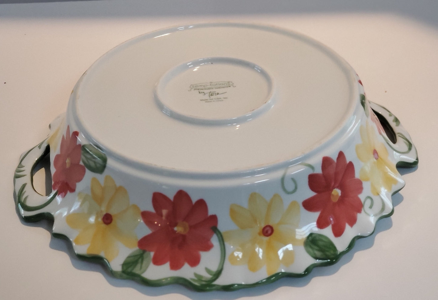 Round Serving Dish With Metal Carrier 14” Round/Diameter Dish is White With Red & Yellow Flowers & Green Leaf Design Carrier is White Criss/Cross Metal withTwo (2) Handles & Removable Rattan Bottom