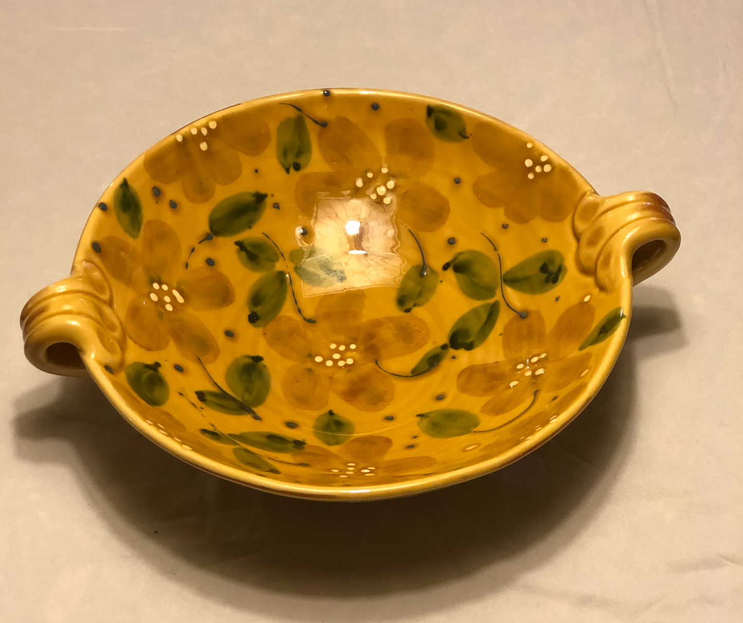 Ceramic Bowl - Approx: 12” Diameter  Two (2) handles for easy carrying  Handle-to-Handle - Approx: 15”  Gold Background with Green & Cream Leaf Design  Made in Italy for Vietri